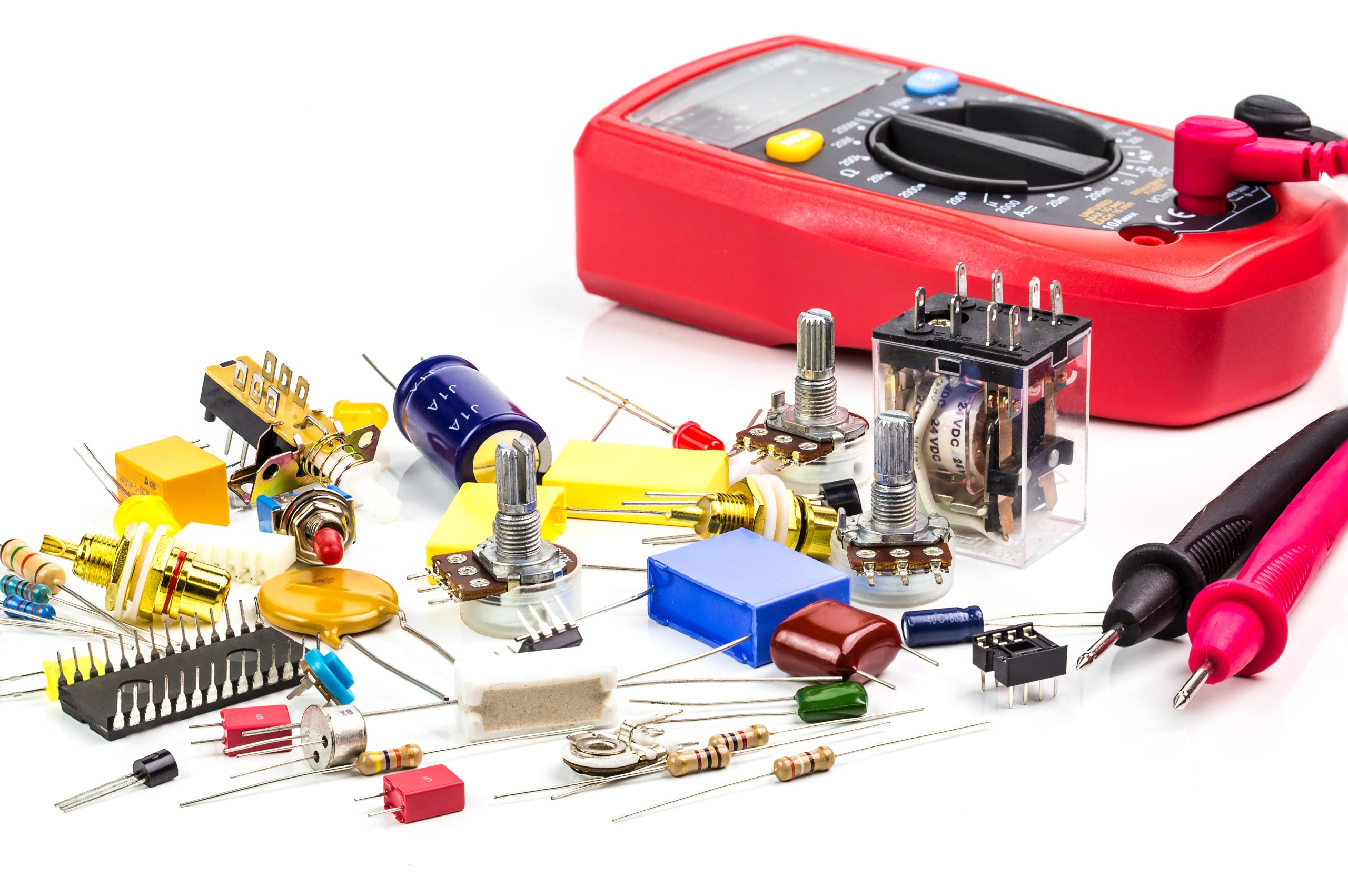 Electronics component and digital multimeter on white background, selective focus